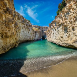 Papafragas hidden beach with crystal clear turquoise water and tunnel rock formations in Milos island, Greece